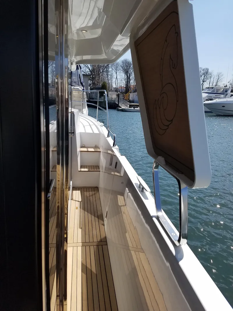 Slide: The Image of 2019 Beneteau Swift Trawler 35, side deck view, docked at marina. - 13