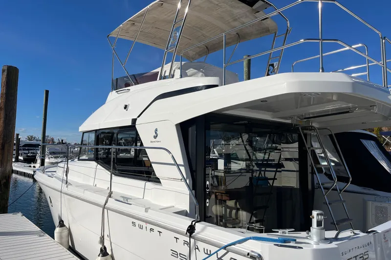 Slide: The Image of 2019 Beneteau Swift Trawler 35 docked at marina, showcasing sleek design and spacious deck. - 15