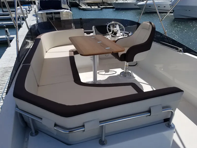 Slide: The Image of 2019 Beneteau Swift Trawler 35, elegant seating and helm, docked at marina. - 22