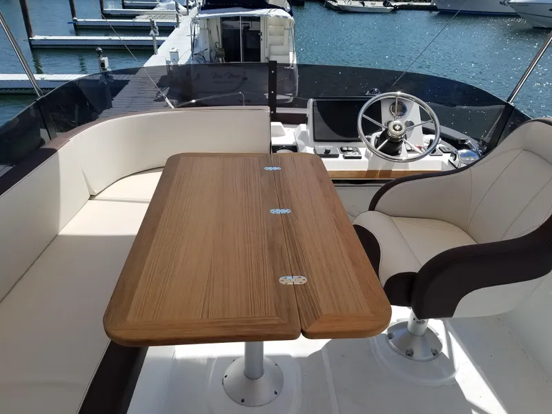Slide: The Image of Flybridge seating area on 2019 Beneteau Swift Trawler 35 with table and helm. - 23