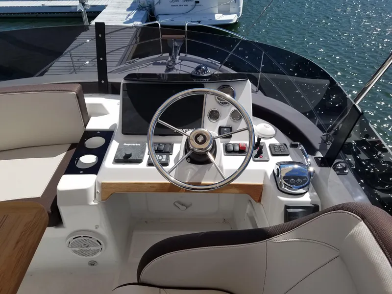Slide: The Image of Cockpit of 2019 Beneteau Swift Trawler 35 with steering wheel and navigation controls. - 24