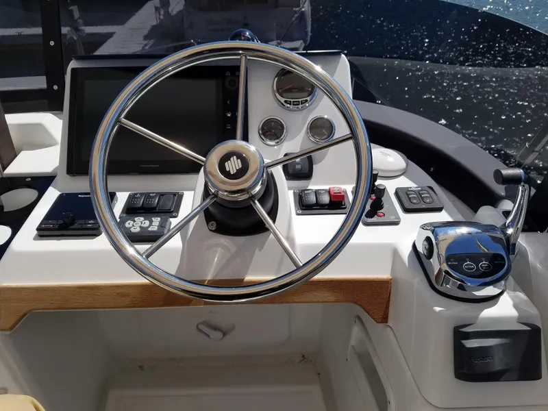 Slide: The Image of 2019 Beneteau Swift Trawler 35 helm with steering wheel and navigation controls. - 25