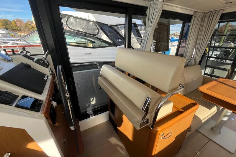 Slide: The Image of Interior of 2019 Beneteau Swift Trawler 35, featuring helm and seating area. - 36