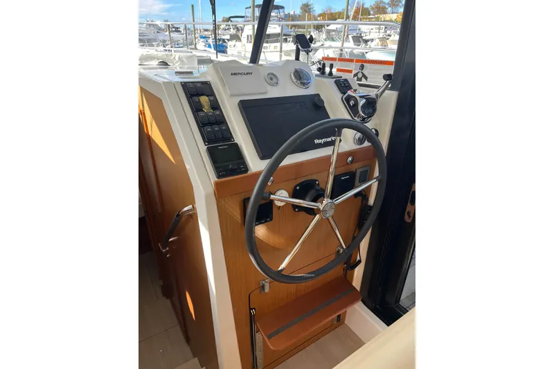 Slide: The Image of 2019 Beneteau Swift Trawler 35 helm with steering wheel and navigation controls. - 38