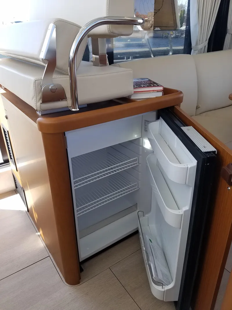Slide: The Image of 2019 Beneteau Swift Trawler 35 interior with open mini fridge and modern sink. - 40