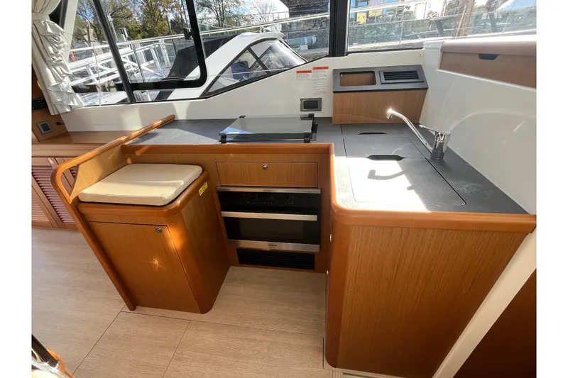 Slide: The Image of 2019 Beneteau Swift Trawler 35 interior kitchen with wood cabinetry and modern appliances. - 42