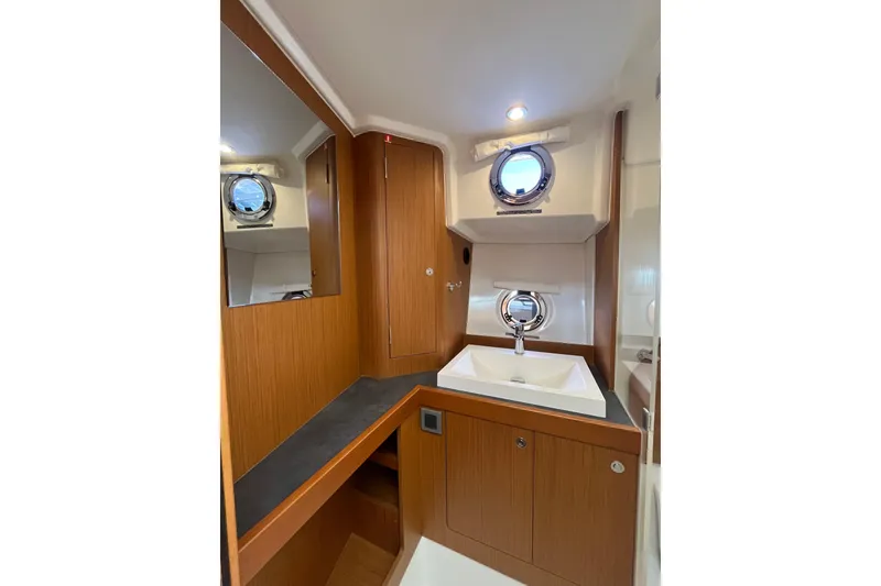 Slide: The Image of 2019 Beneteau Swift Trawler 35 bathroom with wood cabinetry and porthole window. - 56