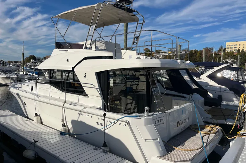 Slide: The Image of 2019 Beneteau Swift Trawler 35 docked at marina under clear blue sky. - 7