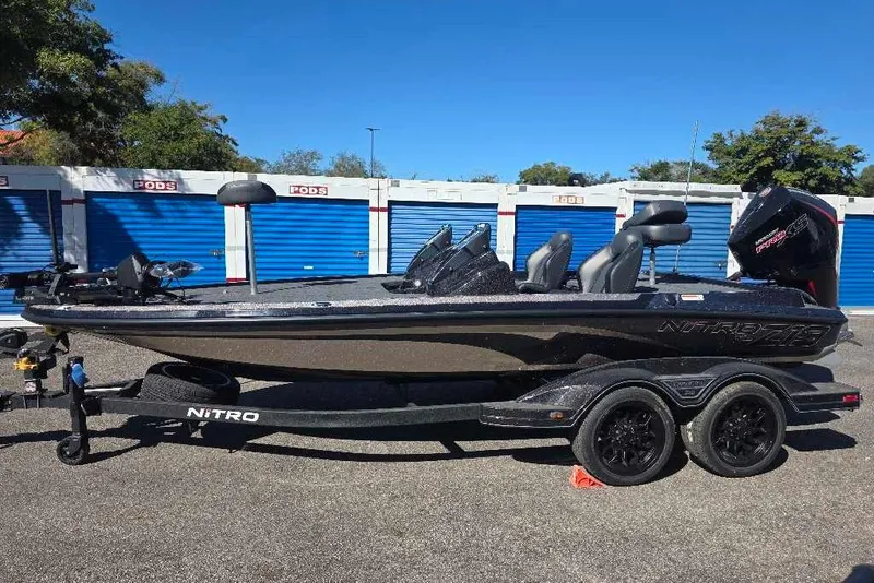 Slide: The Image of 2026 Nitro Z19 XL Pro boat on trailer, parked near storage units. - 2