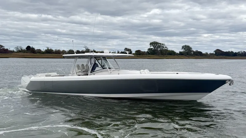 Slide: The Image of A 2019 Intrepid 475 Panacea cruising on calm waters. The sky is overcast. - 1
