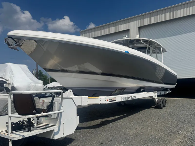 Slide: The Image of A 2019 Intrepid 475 Panacea on a trailer in front of a large building. - 2