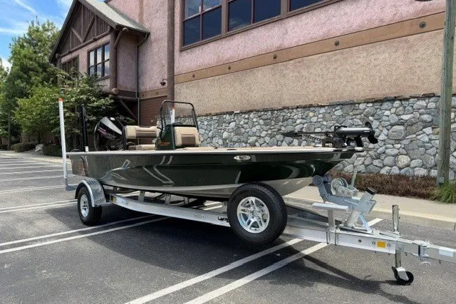 Slide: The Image of 2026 Mako 18 Pro Skiff Backwater Edition on trailer, parked near a stone building. - 5