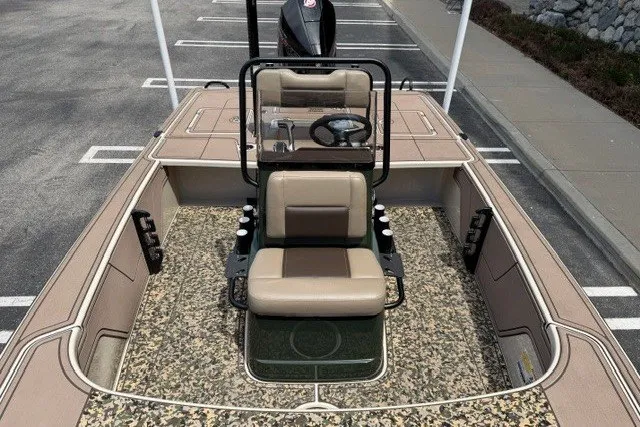 Slide: The Image of 2026 Mako 18 Pro Skiff Backwater Edition boat with camouflage flooring and beige seating. - 9