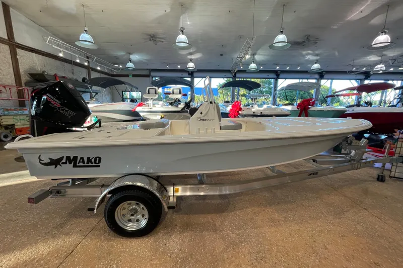 The Image of 2026 Mako 18 Pro Skiff boat displayed indoors on a trailer. - 0