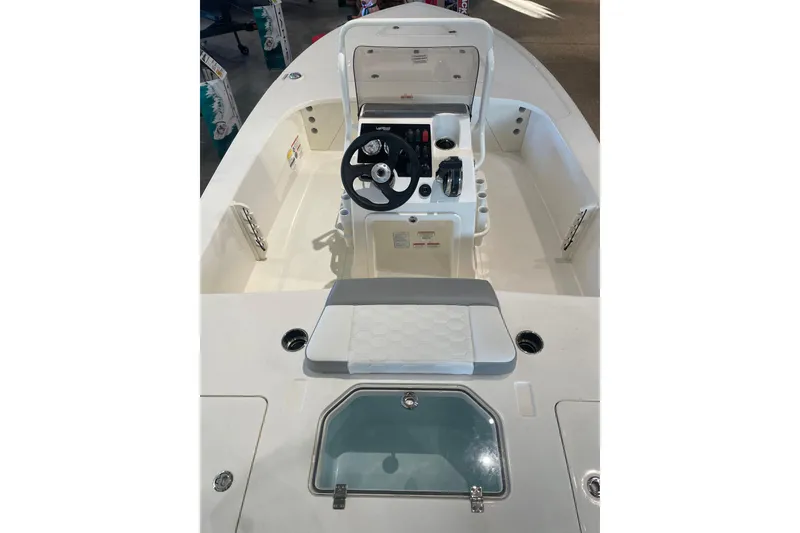 Slide: The Image of 2026 Mako 18 Pro Skiff boat interior with steering console and seating. - 2