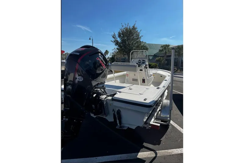 Slide: The Image of 2025 Mako 18 LTS boat with powerful outboard motor in a sunny parking lot. - 1