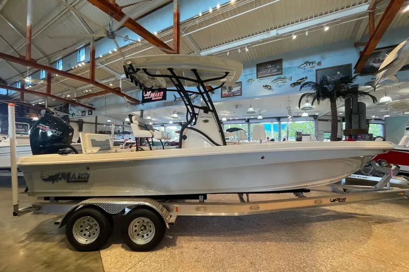 The Image of 2026 Mako 24 APEX boat displayed in a showroom on a trailer. - 0