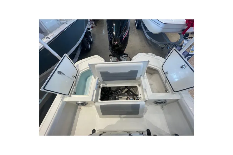 Slide: The Image of 2026 Mako 24 APEX boat interior with open storage compartments and visible engine. - 10