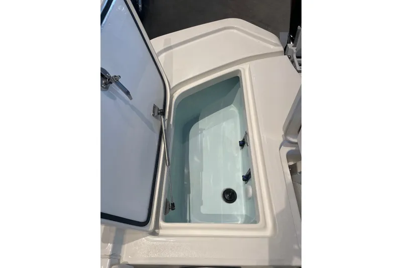 Slide: The Image of Open storage compartment on 2026 Mako 24 APEX boat, showcasing interior space. - 12