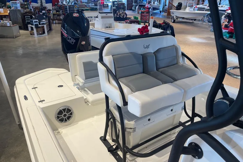 Slide: The Image of 2026 Mako 24 APEX boat interior with seating and motor in showroom. - 7