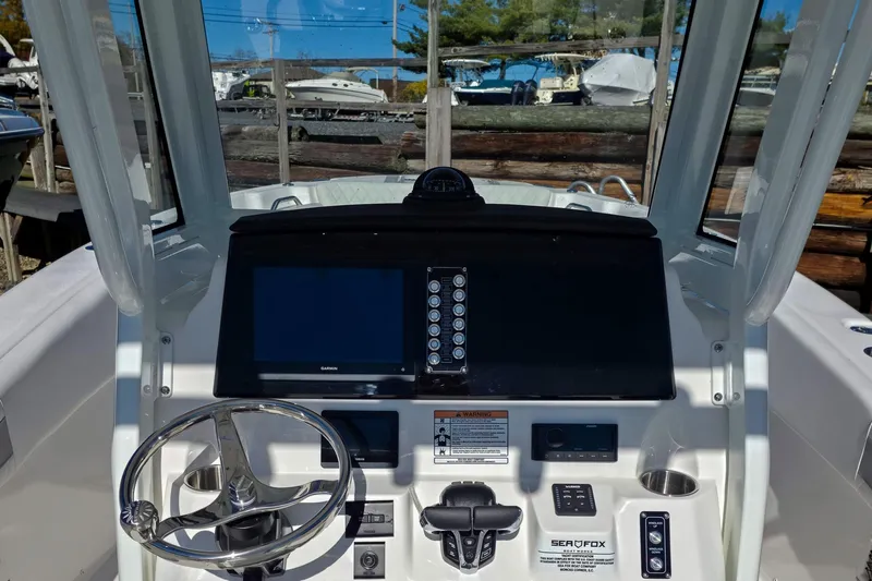 Slide: The Image of 2026 Sea Fox 268 Commander boat dashboard with steering wheel and navigation controls. - 12