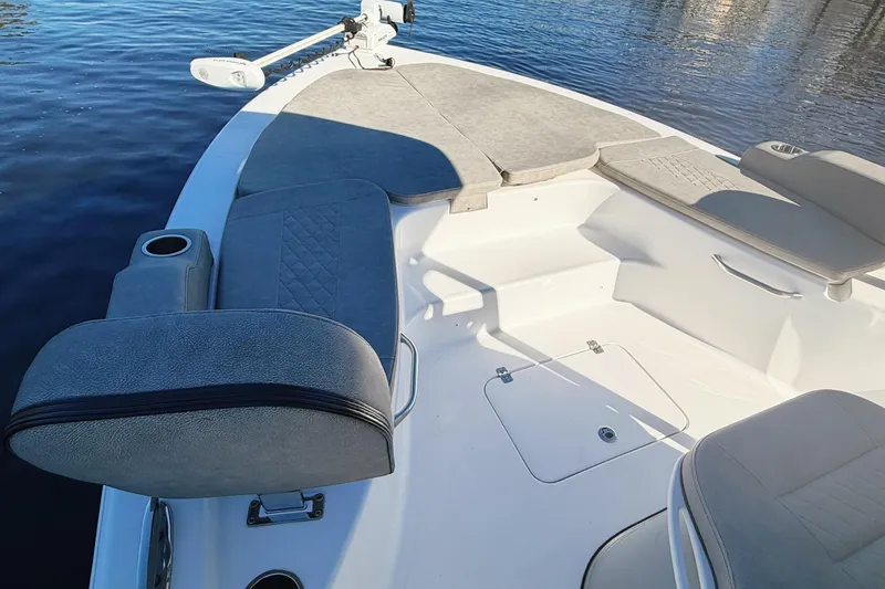 Slide: The Image of 2021 Sea Pro 248 Bay boat interior with cushioned seating and cup holder on calm water. - 10