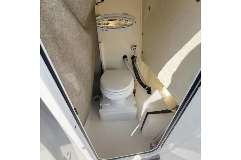 Slide: The Image of 2021 Sea Pro 248 Bay boat interior with compact marine toilet setup. - 11