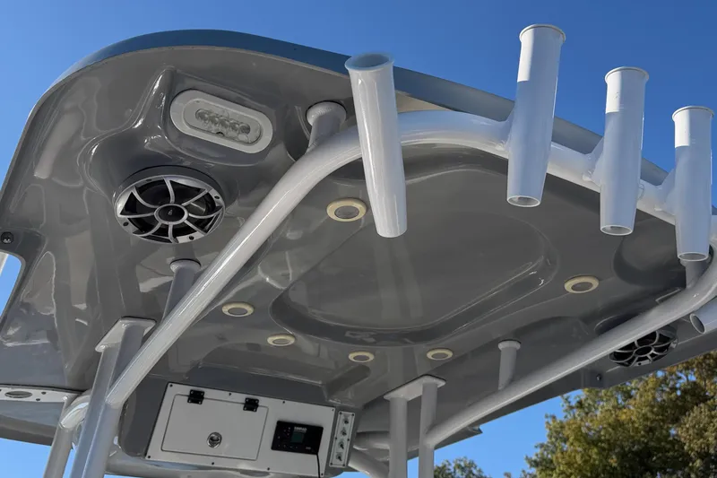 Slide: The Image of 2021 Sea Pro 248 Bay boat T-top with rod holders and speakers against blue sky. - 18