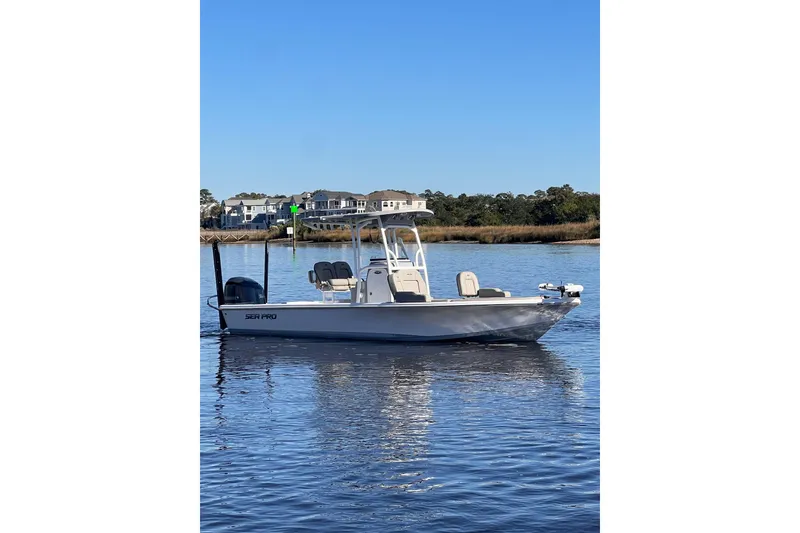 Slide: The Image of 2021 Sea Pro 248 Bay boat on calm water, clear sky background. - 2