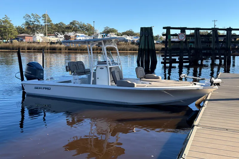 Slide: The Image of 2021 Sea Pro 248 Bay boat docked on calm water, clear sky background. - 3
