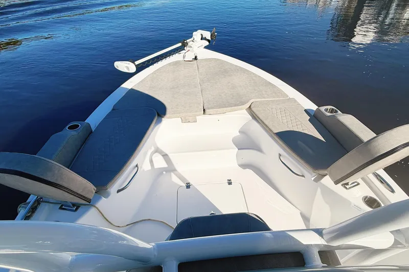 Slide: The Image of 2021 Sea Pro 248 Bay boat interior with cushioned seating and calm water view. - 9