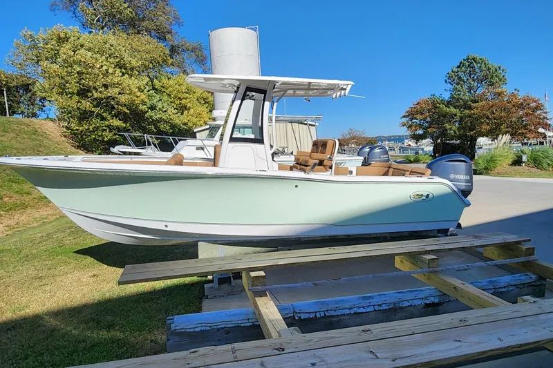 Slide: The Image of 2023 Sea Hunt Ultra 239 SE boat on display outdoors, featuring Yamaha engines. - 2