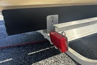 Slide: The Image of 2018 Carolina Skiff Ultra Series trailer with red reflector on asphalt surface. - 6