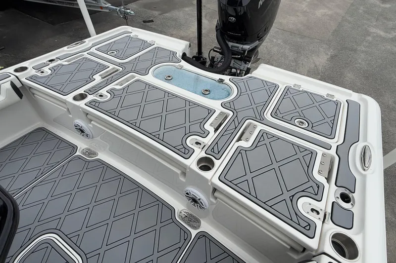 Slide: The Image of 2024 Tidewater 2500 Carolina Bay boat deck with gray non-slip surface and storage compartments. - 11