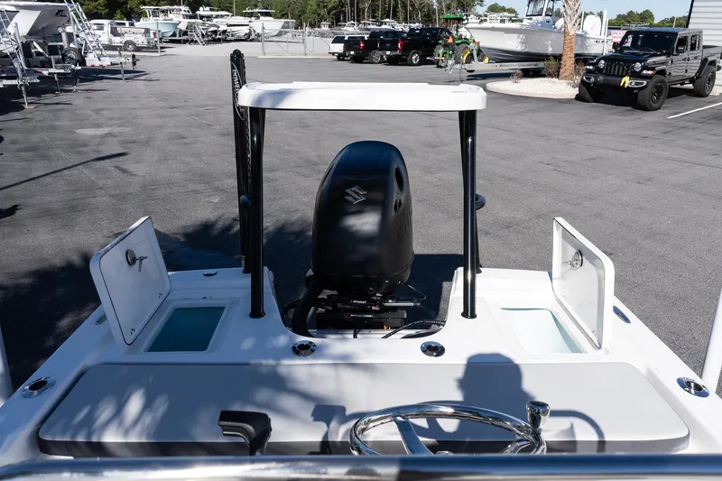 Slide: The Image of 2026 Sea Pro 172 Bay boat with open compartments and outboard motor in a parking lot. - 12