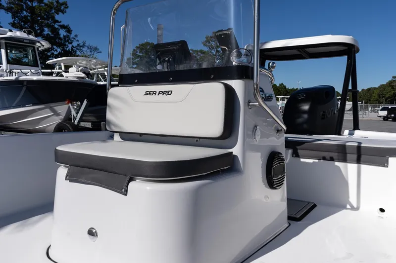 Slide: The Image of 2026 Sea Pro 172 Bay boat interior with seating and console, parked outdoors. - 17