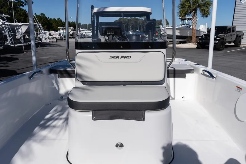 Slide: The Image of 2026 Sea Pro 172 Bay boat interior with seating and console, parked outdoors. - 18