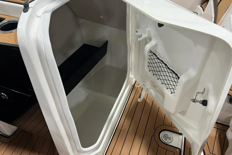 Slide: The Image of Open storage compartment on 2025 Yamaha Boats 252SD, featuring wooden flooring and netted pocket. - 10