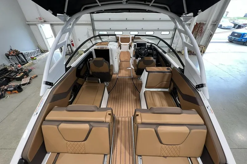 Slide: The Image of 2025 Yamaha Boats 252SD interior with tan seating and sleek design in a garage setting. - 3