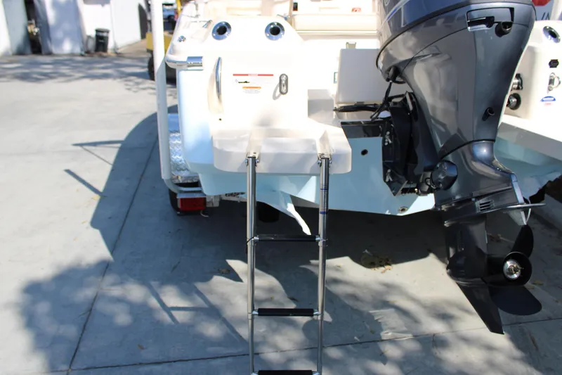 Slide: The Image of 2026 Scout 188 Sportfish boat with motor and ladder on a trailer. - 7