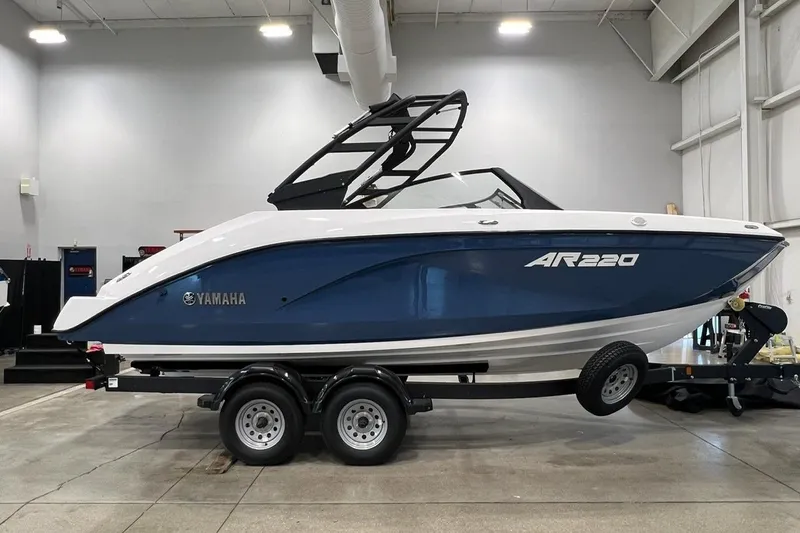 The Image of 2025 Yamaha Boats AR220 on trailer in indoor showroom setting. - 0