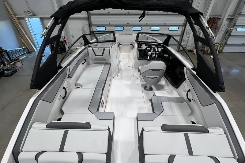 Slide: The Image of 2025 Yamaha Boats AR220 interior with sleek seating and modern design in a showroom. - 4