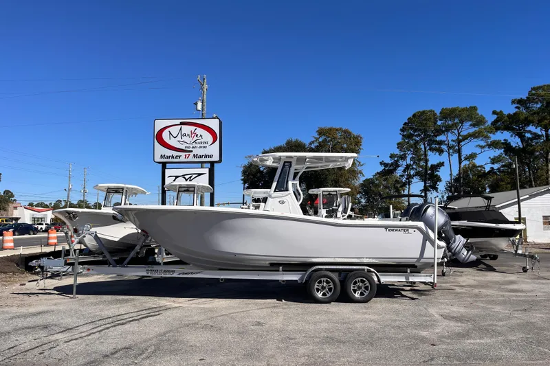 Slide: The Image of 2026 Tidewater 256 LXF boat on trailer at Marker 17 Marine dealership. - 2