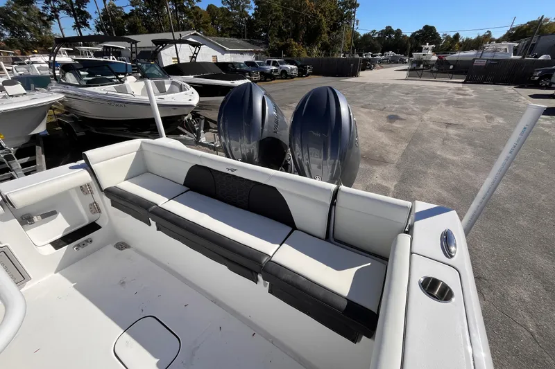 Slide: The Image of 2026 Tidewater 256 LXF boat with dual engines and spacious seating in a marina setting. - 7
