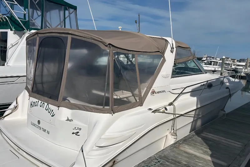 Slide: The Image of 1997 Sea Ray 330 Sundancer docked, featuring tan canopy and sleek design. - 3