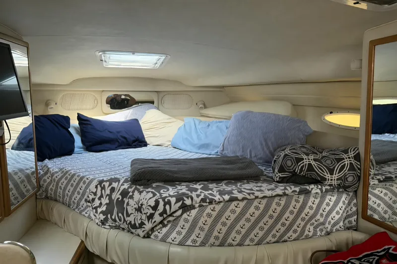 Slide: The Image of Cozy cabin interior of 1997 Sea Ray 330 Sundancer with plush bedding and pillows. - 5