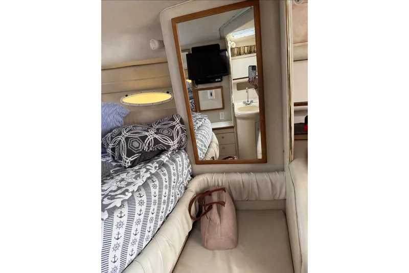 Slide: The Image of 1997 Sea Ray 330 Sundancer cabin interior with bed, mirror, and porthole window. - 8