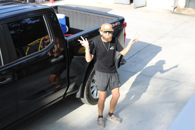 Slide: The Image of Man posing with peace signs beside a black truck, Starcraft EXS 1 Q DH 2026. - 17