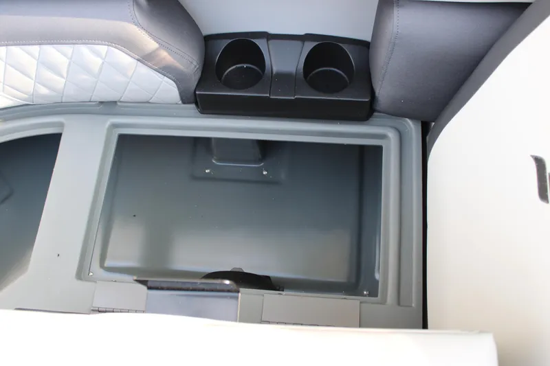 Slide: The Image of Starcraft EXS 1 Q DH 2026 boat storage compartment with cup holders and quilted seating. - 24
