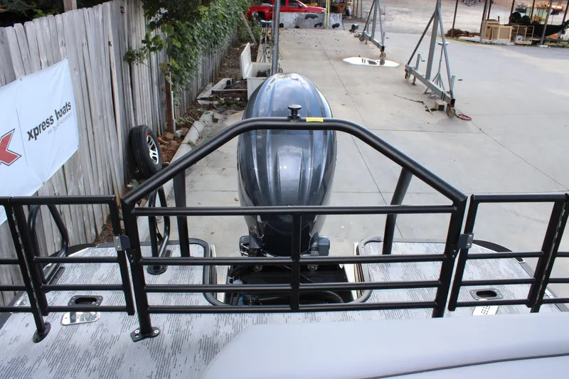 Slide: The Image of 2026 Starcraft EXS 1 Q DH boat with outboard motor, docked near a wooden fence. - 7